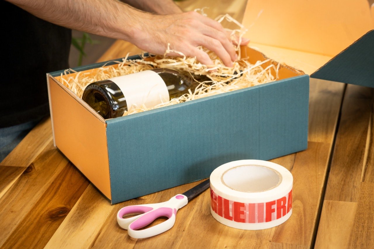 Une bouteille de vin calée dans un coffret cadeau avec de la frisure de bois