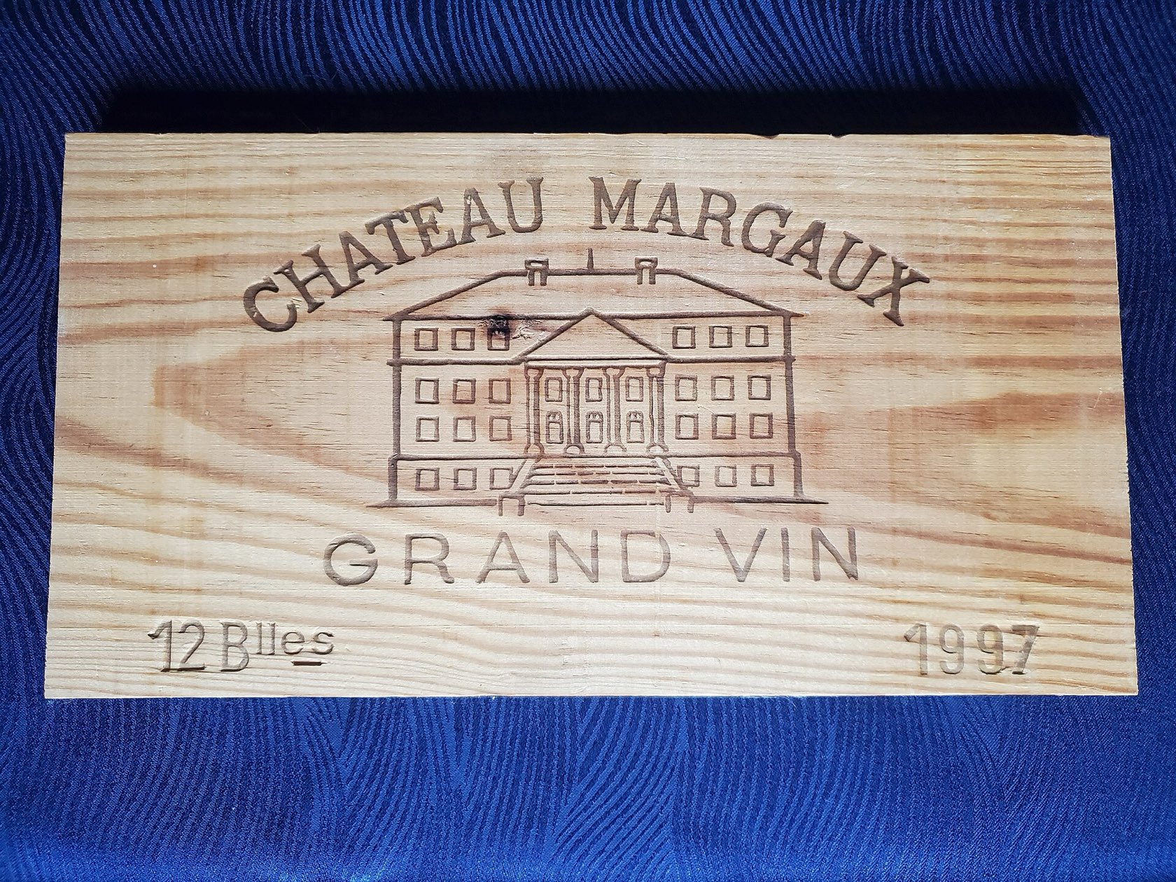 Le panneau d’une caisse en bois de 12 bouteilles de Château Margaux 1997, gravé du nom du château