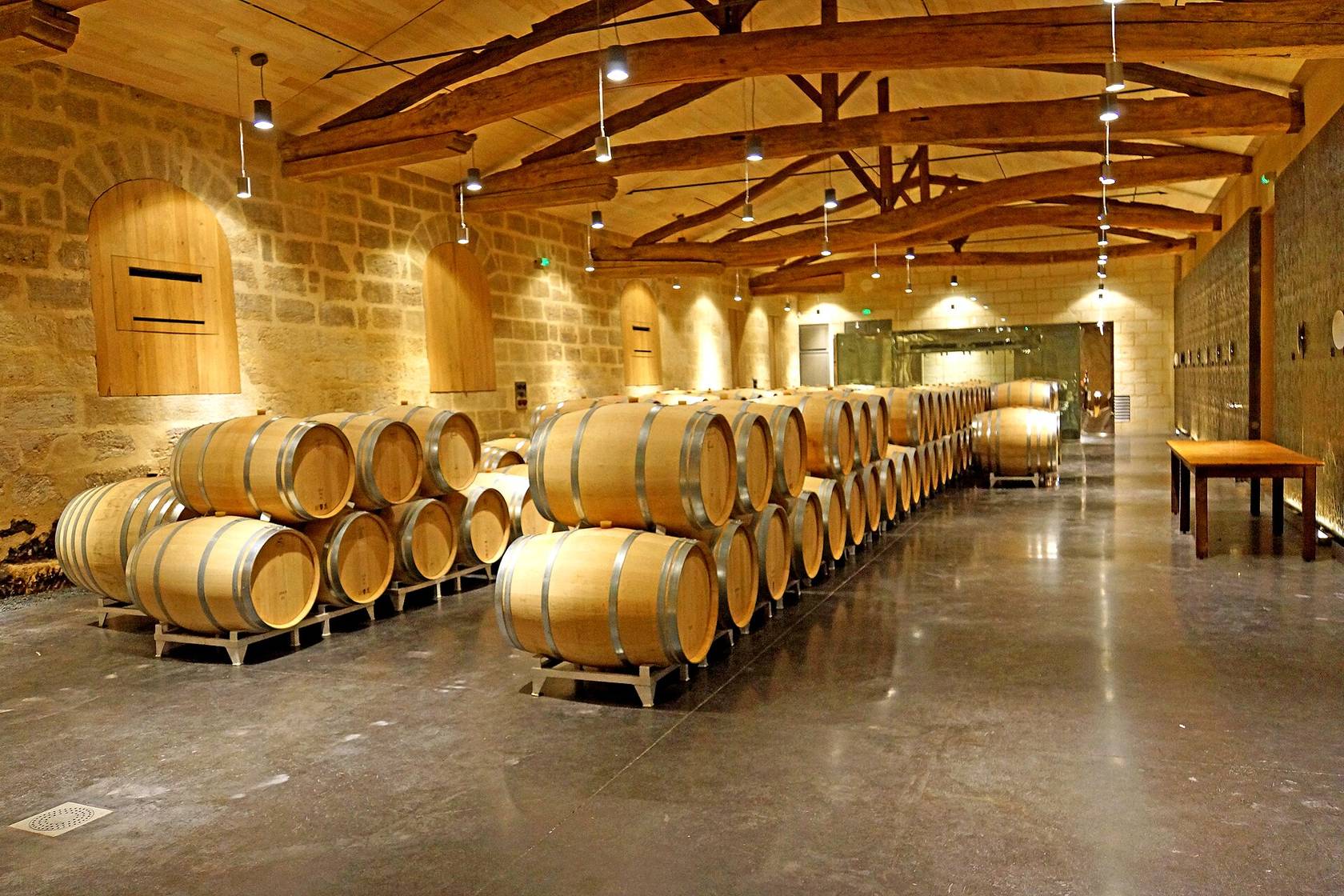 Le chai à barriques du château Soutard, à Saint-Émilion, avec ses rangées de barriques sous une charpente en bois