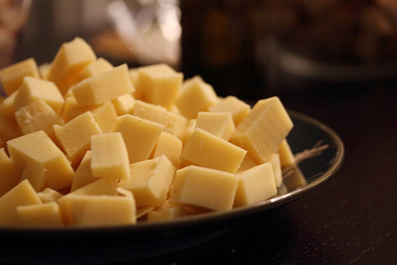 Des dés de fromage à pâte pressée dans un saladier, prêts pour une fondue savoyarde