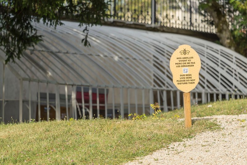 Panneau signalant les ruches devant l’ancienne serre du parc du Domaine Gosset