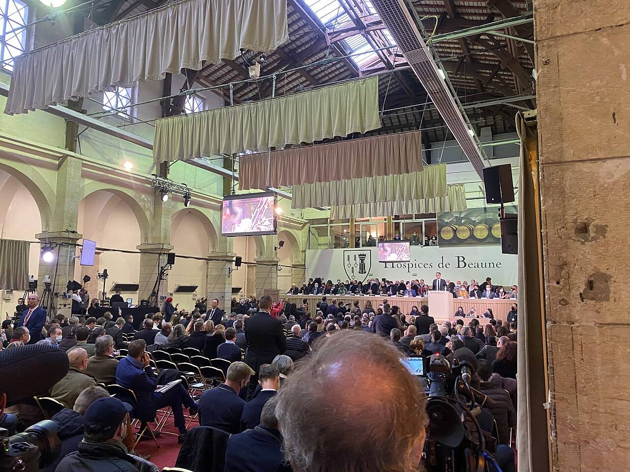 La halle de Beaune pleine de public, face à la tribune des commissaires-priseurs, pendant la vente aux enchères des vins des Hospices de Beaune