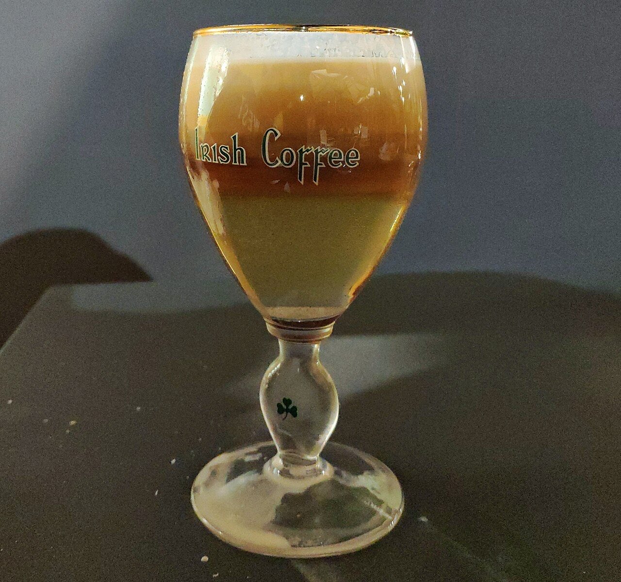 Un Irish Coffee dans le verre à pied qui porte son nom, orné d’un trèfle