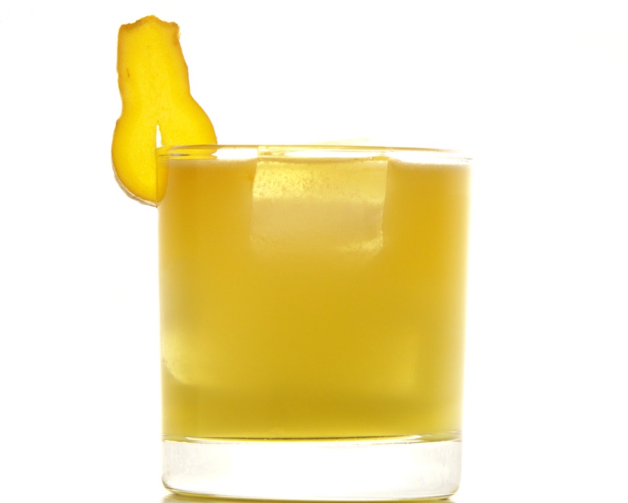 Un Penicillin doré dans un verre bas, garni d’une tranche de gingembre