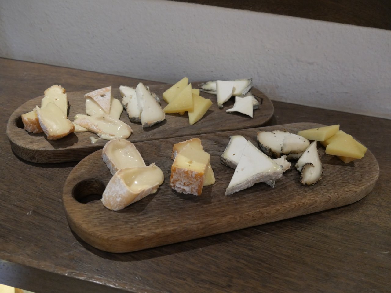 Deux plateaux de fromages servis dans un bar à vin