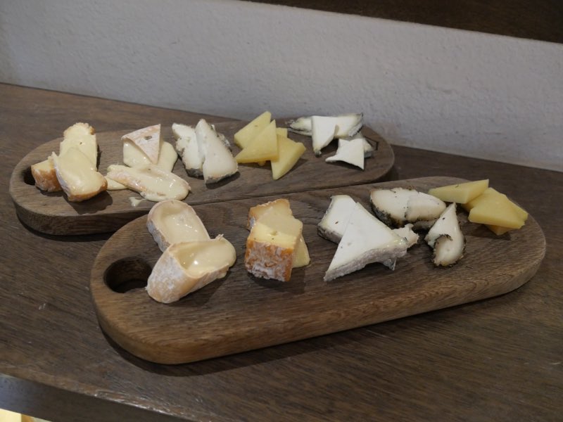 Deux plateaux de fromages servis dans un bar à vin