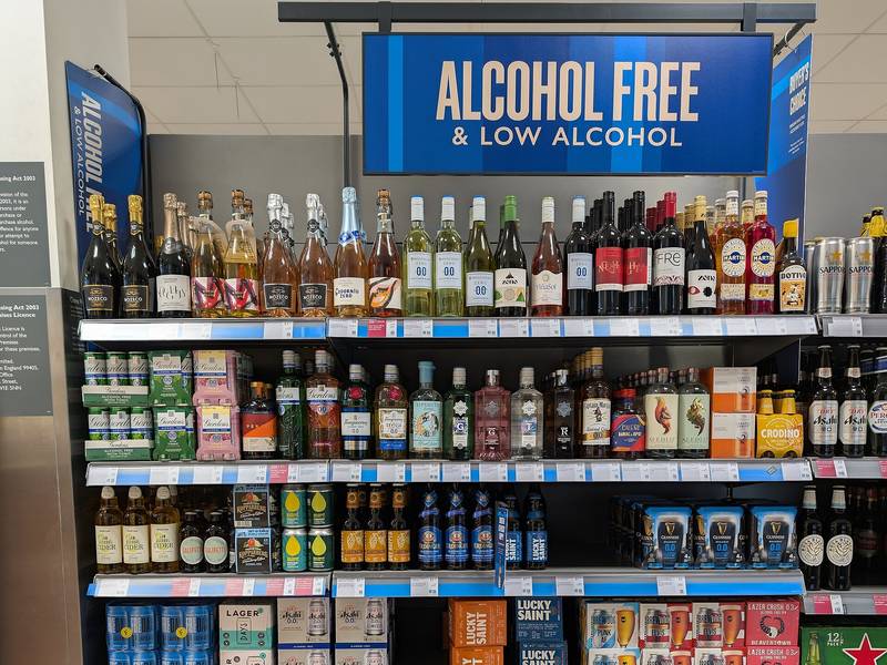 Le rayon sans alcool d’un supermarché britannique sous un panneau «&nbsp;Alcohol free & low alcohol&nbsp;» : effervescents, blancs, rosés et rouges à 0,0 %, puis spiritueux et bières sans alcool