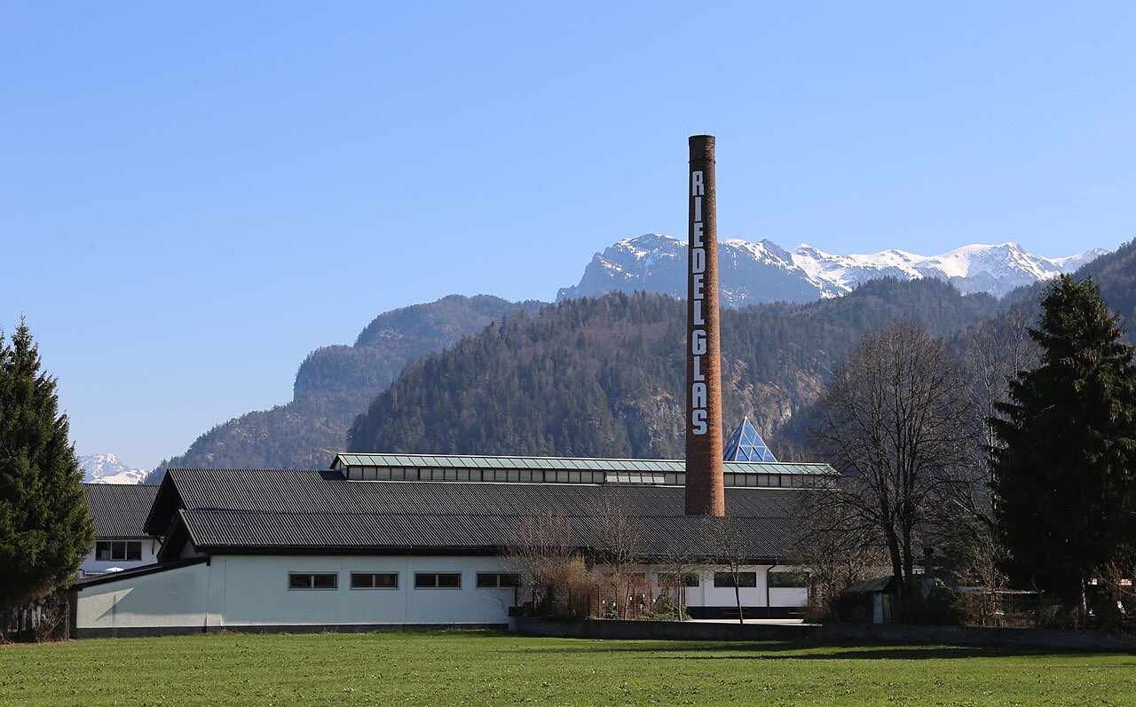 L’usine Riedel de Kufstein et sa cheminée marquée Riedel Glas, au pied des montagnes