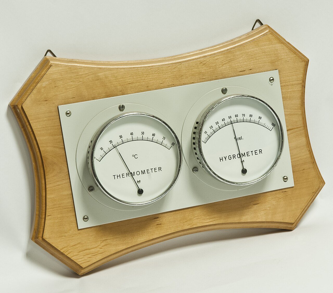 Un thermomètre et un hygromètre à cadran, montés côte à côte sur une planchette en bois