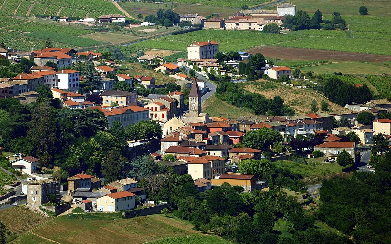 Les toits du village de Vaux-en-Beaujolais au creux du vallon, entourés de vignes