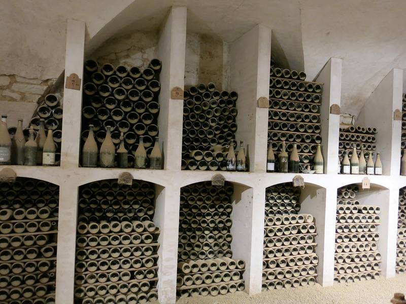 Des niches voûtées blanchies à la chaux, remplies de vieilles bouteilles couchées et couvertes de poussière, dans la cave du château de Valençay