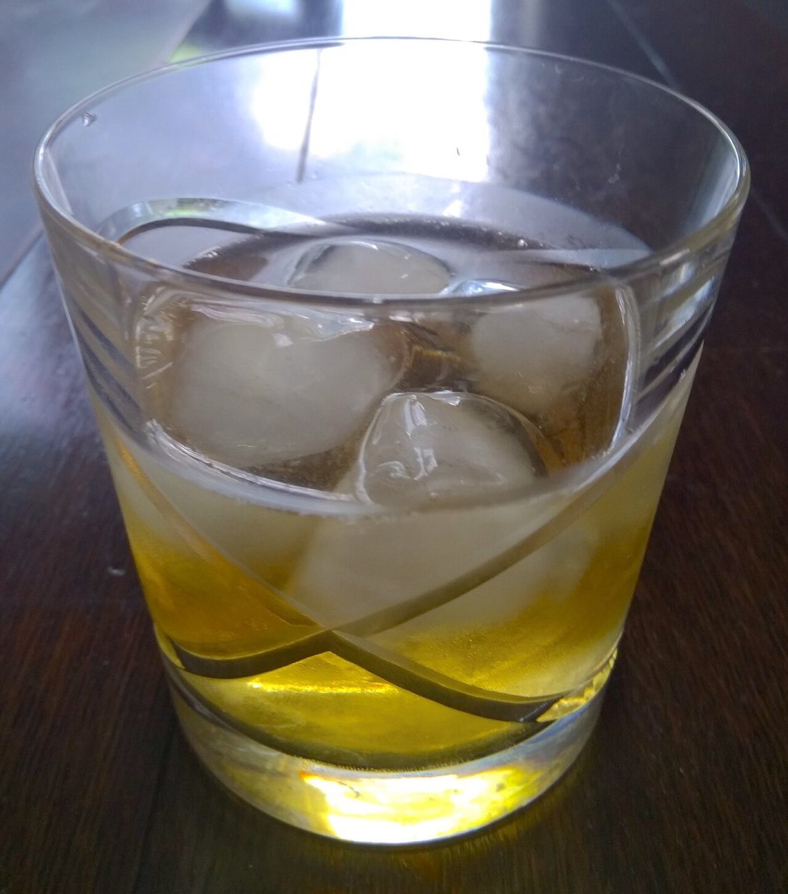 Un verre bas de whisky allongé d’eau gazeuse, sur de gros glaçons