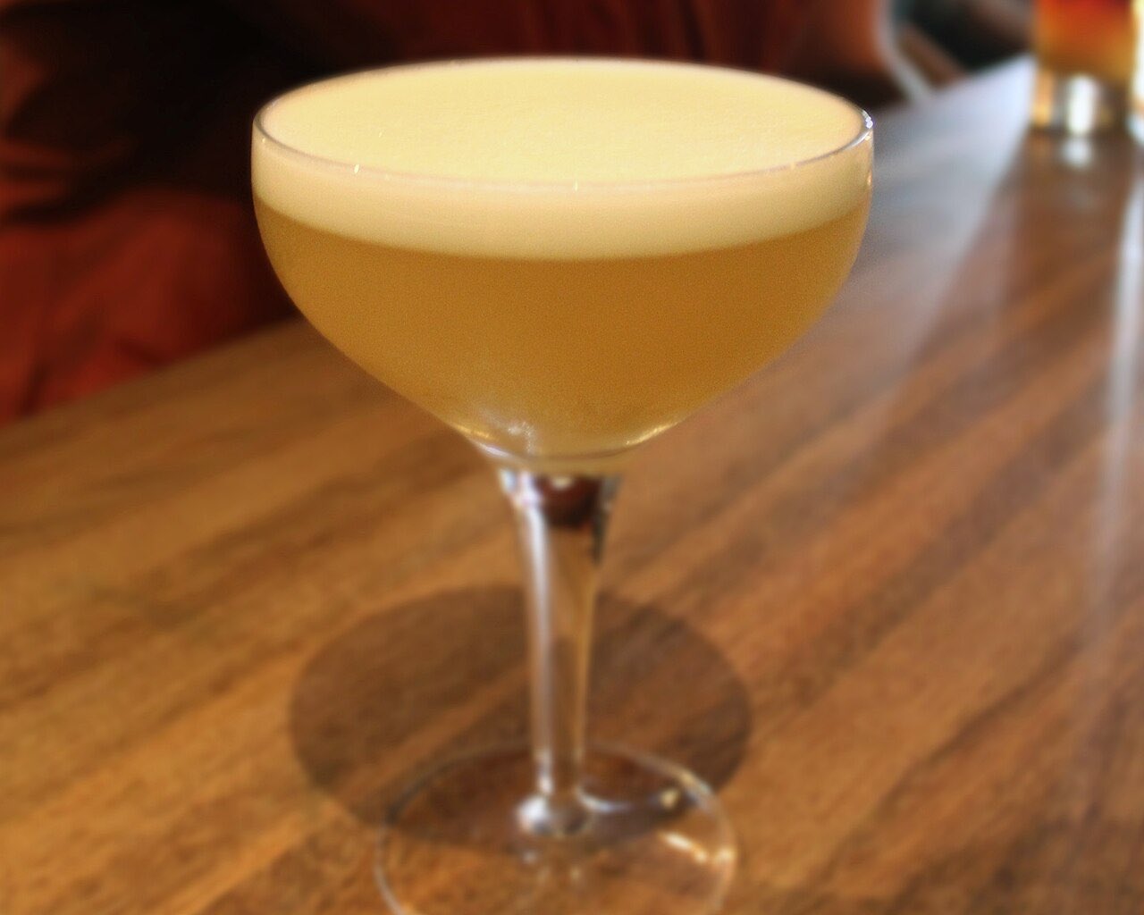 Un Whisky Sour servi sans glace dans une coupe, sous une couche de mousse